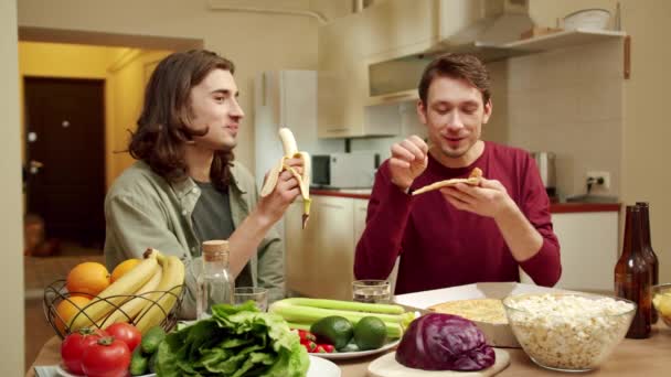 한 친구는 바나나를 먹고 있고, 다른 친구는 피자를 먹고 있습니다. — 비디오