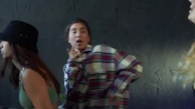 Üç genç kızın evde doğaçlama dans etmesi.