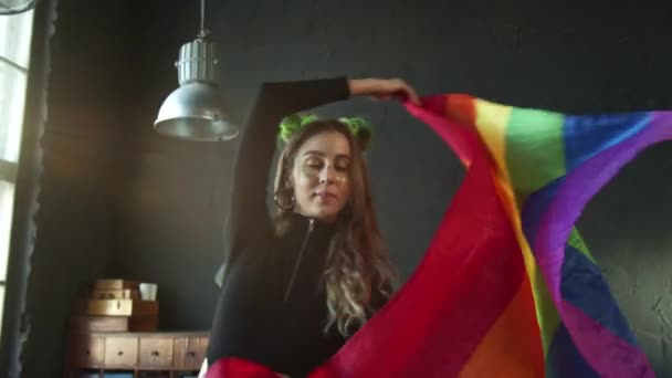 Piękna dziewczyna wisząca w studio machająca flagą dumy LGBT — Wideo stockowe