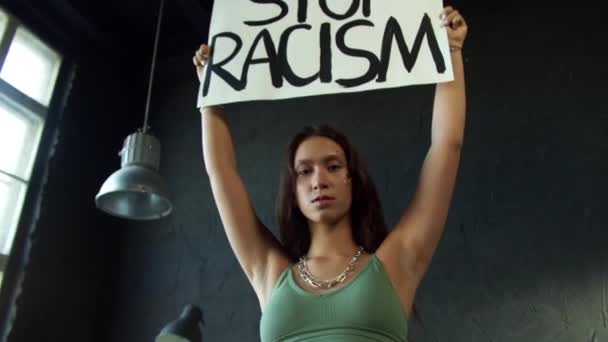 Młoda hipsterka trzyma sztandar protestu domagając się zaprzestania dyskryminacji rasowej — Wideo stockowe