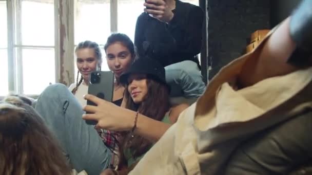 Unge mennesker som lager en felles selfie mens de sitter på en sofa – stockvideo