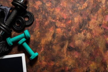 Evde egzersiz yapmak için ağırlık ve aksesuarlar ve online egzersiz için bir tablet. Sağlıklı yaşam konsepti