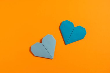 Sevgililer Günü 'nde birbirlerine aşık çiftler için sarı arka planda renkli kağıtlardan yapılmış Origami kalpleri. Aşk konsepti