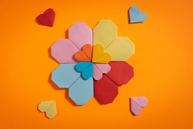 Sevgililer Günü 'nde birbirlerine aşık çiftler için sarı arka planda renkli kağıtlardan yapılmış Origami kalpleri. Aşk konsepti
