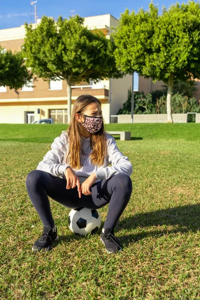 Hermosa Niña Sentada Encima Pelota Fútbol Lleva Una Máscara Para — Foto de Stock