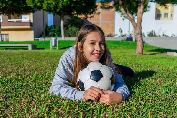 Linda Niña Sonriente Acostada Césped Bonito Parque Con Pelota Fútbol — Foto de Stock