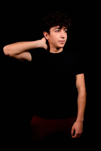 Attraktiver Junger Mann Mit Lockigem Haar Der Auf Schwarzem Hintergrund — Stockfoto