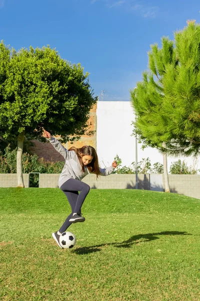 晴れた冬の日には天然芝の素敵な公園でサッカーをしている美しい少女 運動と健康的な生活の概念 — ストック写真