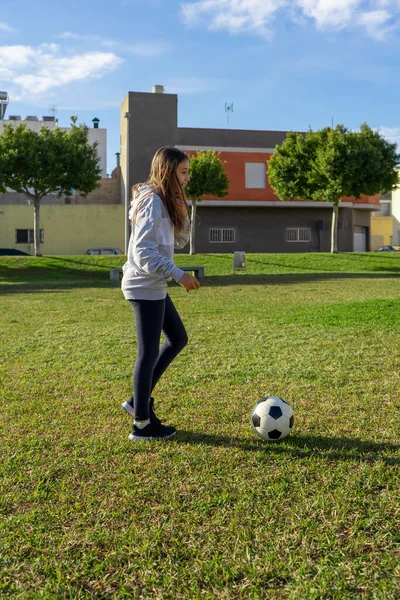 晴れた冬の日には天然芝の素敵な公園でサッカーをしている美しい少女 運動と健康的な生活の概念 — ストック写真