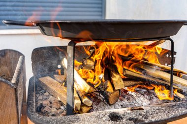 Valensiyalı Paella ızgarada pişiriliyor. Yanında da bir sürü meşe ağacı var. Tipik İspanyol yemekleri. Seçici odaklanma. Sağlıklı gıda konsepti