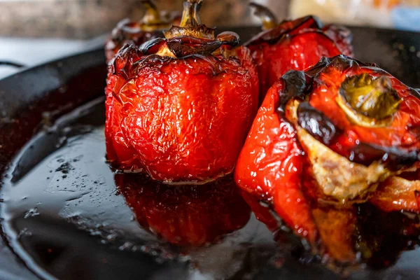 Kırmızı biberler fırında kavrulmuş etle doldurulmuş siyah paella içinde. Seçici odaklanma. Yiyecek konsepti