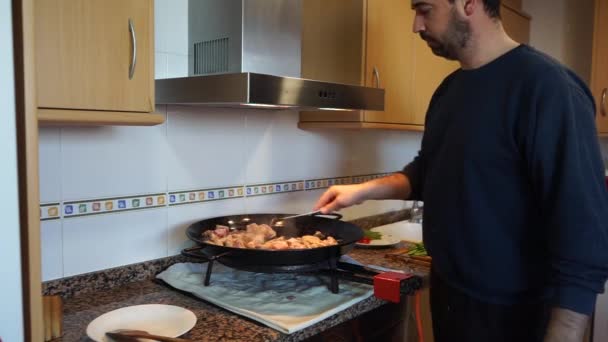 Een Man Met Baard Die Kip Varkensvlees Een Paella Roert — Stockvideo