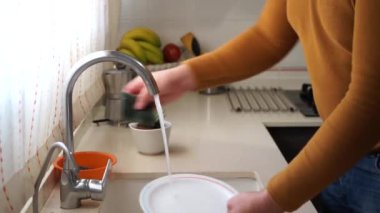 Mutfakta tabak ovalayan bir adamın elleri. Ev işi kavramı