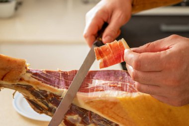 Evdeki mutfakta insan eliyle yapılan jambonun ayrıntıları. Süper yiyecekler. Lezzetli aperatif. Gurme yemek konsepti