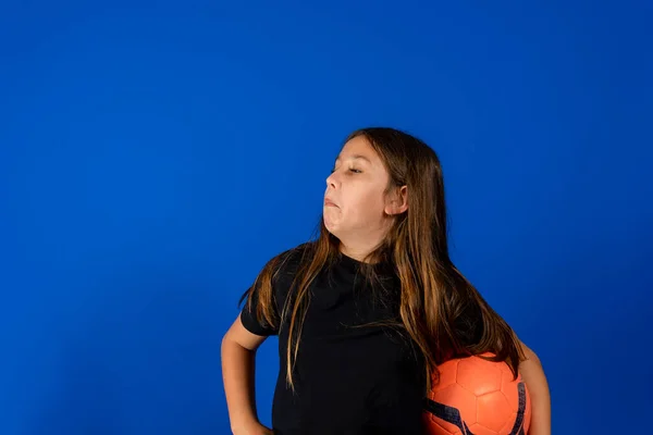 Pěkné Předpuberťačka Pózuje Legrační Fotbalovým Míčem Izolované Modrém Pozadí Studia — Stock fotografie