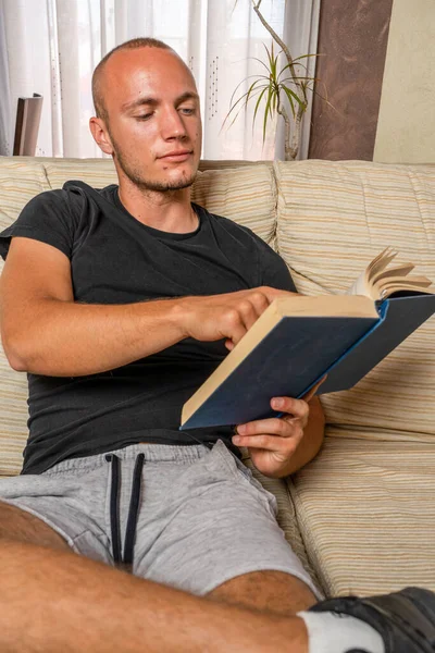 Joven Leyendo Libro Sala Estar Sentado Sofá Concepto Estudio — Foto de Stock