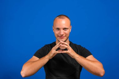 Genç İspanyol bir adam kötü bir plan yaparken ya da mavi arka plana karşı bir numara düşünürken gururlu, yaramaz ve kibirli hissediyor. Şeytani kavram.