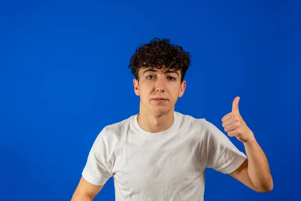 Een knappe Spaanse modelman over een geïsoleerde achtergrond die met de hand een gebaar maakt. Goedkeurende uitdrukking die met succes naar de camera kijkt — Stockfoto