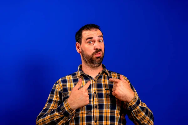 Este sou eu. Retrato de homem narcisista auto-confiante em trabalhador camisa jeans sorrindo satisfeito e apontando-se, sentindo-se auto-importante, orgulhoso, famoso. estúdio tiro isolado no fundo azul — Fotografia de Stock