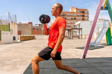 Mükemmel karın kasları olan genç seksi bir sporcu gün batımında sokakta soyunuyor. Sağlıklı yaşam tarzı, düzgün beslenme, eğitim programları ve kilo vermek için beslenme.