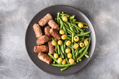 Fasulye kabukları, zeytin ve kızarmış Türk köftesi..