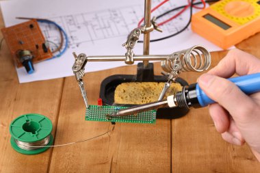 Yardım elini kullanarak elektronik bileşenlerin lehimlenmesi.