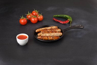 Koyu arkaplanda tencerede domates soslu köfte..