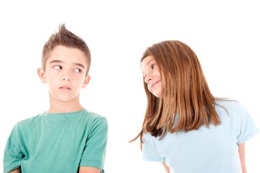 Küçük kız oğlanı öpmeye çalışıyor. Beyazlar içinde.