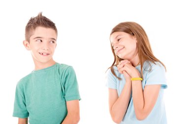 Küçük kız oğlanı öpmeye çalışıyor. Beyazlar içinde.