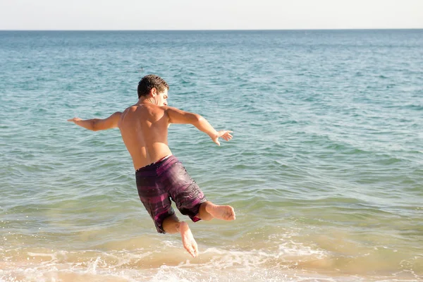 10代の男の子がビーチでスキミングし — ストック写真