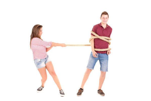 young couple fighting with rope isolated in white