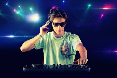 DJ çocuk arka planda ışıkla dans ediyor.