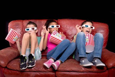Küçük çocuklar 3D gözlüklü film izliyorlar.
