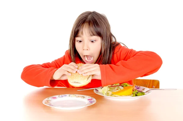 Chica desgarrada entre hamburguesa y verduras — Foto de Stock