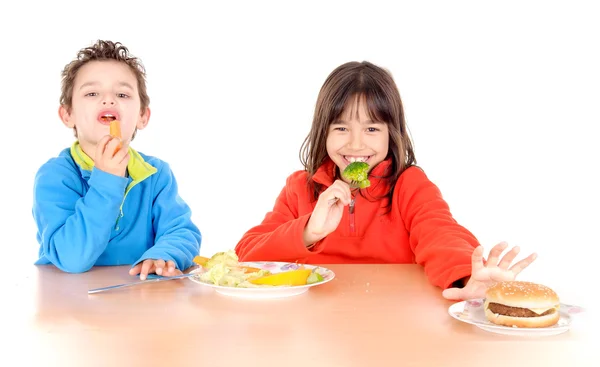 Jongen en meisje eten van groenten en hamburguer — Stockfoto