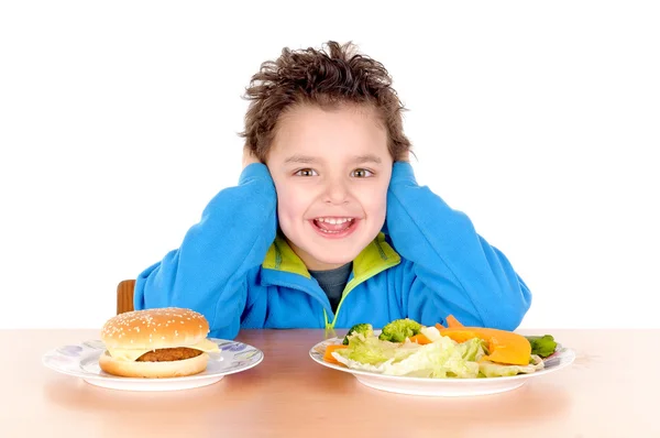Niño desgarrado entre verduras y hamburguesa — Foto de Stock