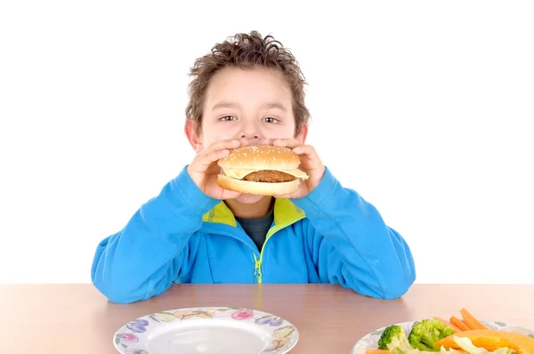 Jongen verscheurd tussen groenten en hamburger — Stockfoto