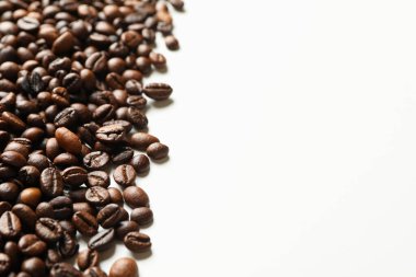 Beyaz arka planda kavrulmuş kahve çekirdekleri, metin için boşluk