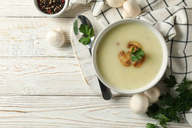 Beyaz ahşap arka planda bir kase mantar çorbası ile lezzetli öğle yemeği kavramı