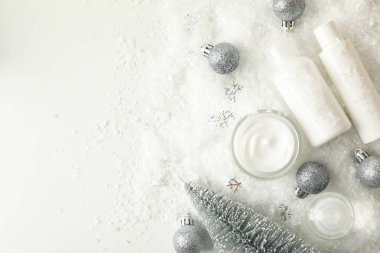 Arka planda kozmetik ürünleri ve dekoratif kar içeren yüz bakımı kavramı