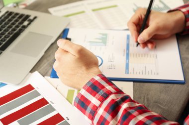 Kırmızı gömlekli genç adam mali planlama ile meşgul.