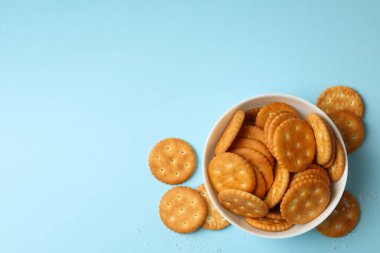 Mavi arka planda lezzetli kraker bisküvileri olan kase