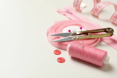 Pembe dikiş malzemeleri beyaz arkaplanda, yakın plan.