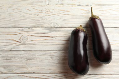 Beyaz ahşap arka planda taze çiğ patlıcan.