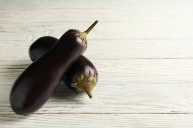 Beyaz ahşap arka planda taze çiğ patlıcan.