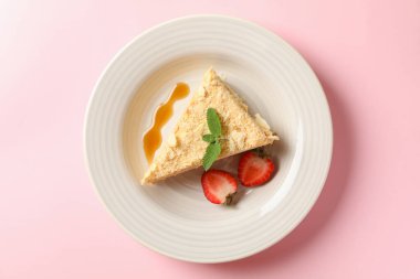 Pembe arka planda nefis Napolyon kekiyle dolu bir tabak.