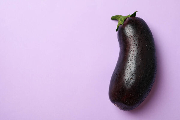 Fresh raw eggplant on violet background, space for text