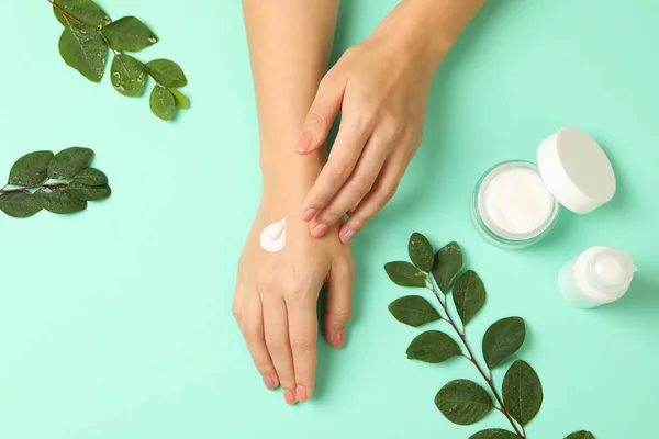 Manos Femeninas Con Crema Cosmética Sobre Fondo Menta — Foto de Stock