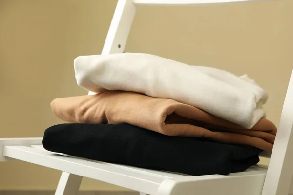 Pile Sweatshirts White Wooden Chair — Stock Photo, Image
