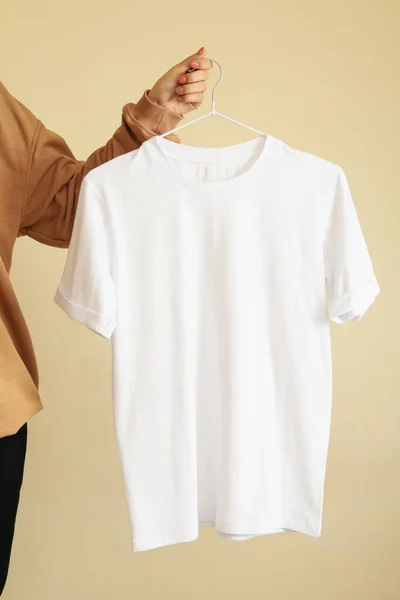 Mulher Segurar Cabide Com Branco Branco Shirt Fundo Bege — Fotografia de Stock